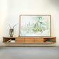 ÉTAUDORÉ San Salvatore wooden entertainment console with a framed abstract painting on a white wall